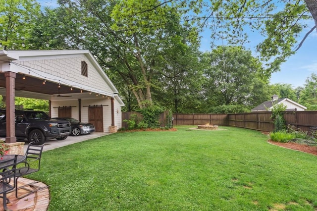 view of yard featuring a fire pit and a detached garage