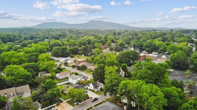 aerial view of residential area featuring mountains and a heavily wooded area