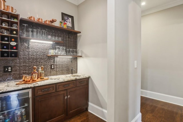 indoor wet bar featuring wine cooler, tasteful backsplash, crown molding, dark wood-style floors, and baseboards