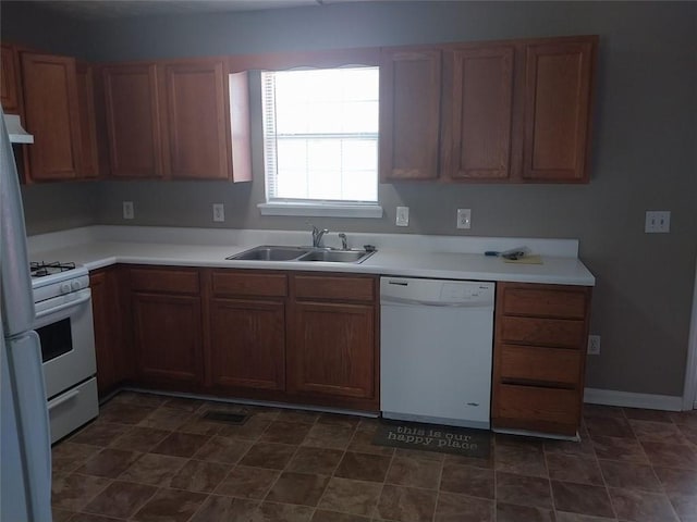 kitchen with range hood, sink, and white appliances