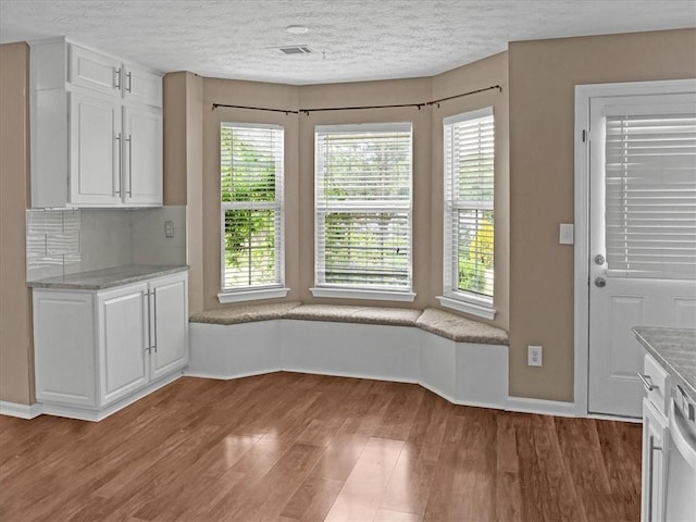 3725 Crescent Walk Ln, Suwanee, GA 30024 - unfurnished dining area featuring light wood finished floors, healthy amount of natural light, and a textured ceiling