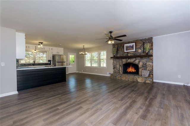 216 Hickory Way, Canton, GA 30115 - unfurnished living room with a ceiling fan, a stone fireplace, a chandelier, and dark wood finished floors