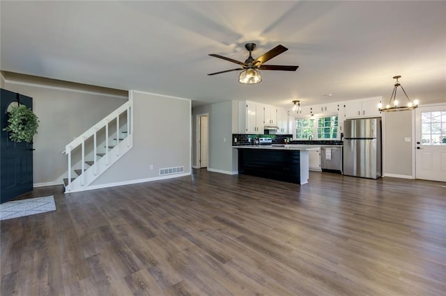 216 Hickory Way, Canton, GA 30115 - unfurnished living room with a chandelier, a ceiling fan, stairway, and dark wood-type flooring
