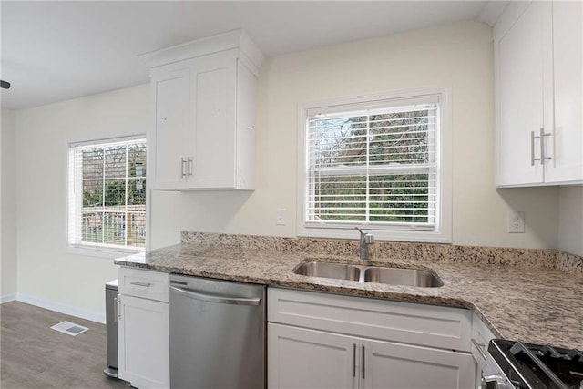 kitchen with light stone counters, visible vents, a sink, stainless steel appliances, and white cabinets