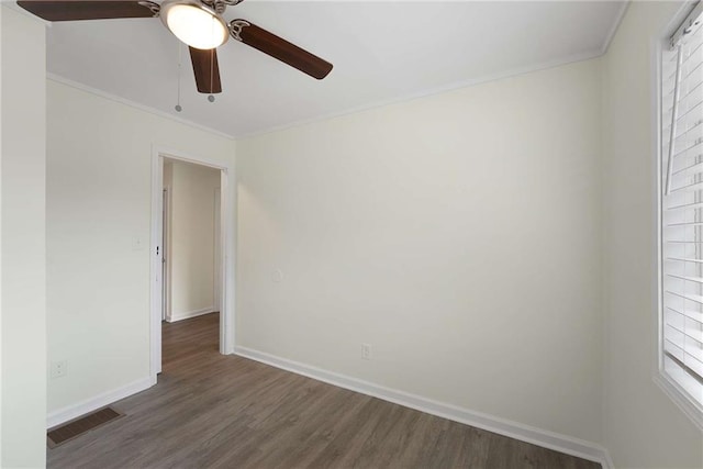 empty room with visible vents, a ceiling fan, crown molding, baseboards, and dark wood-style flooring