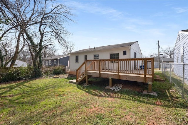 rear view of property with a wooden deck, a lawn, and a fenced backyard