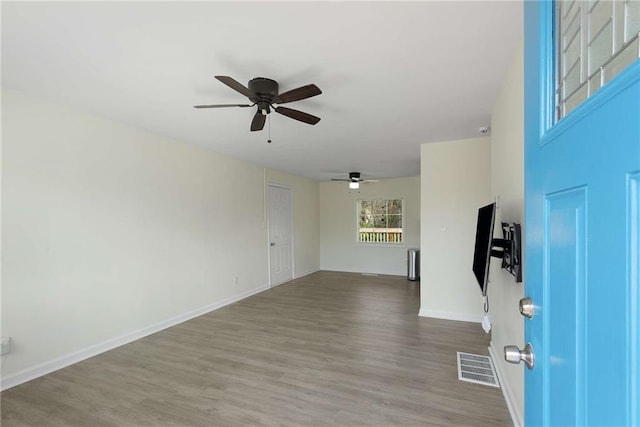 foyer with visible vents, a ceiling fan, baseboards, and wood finished floors