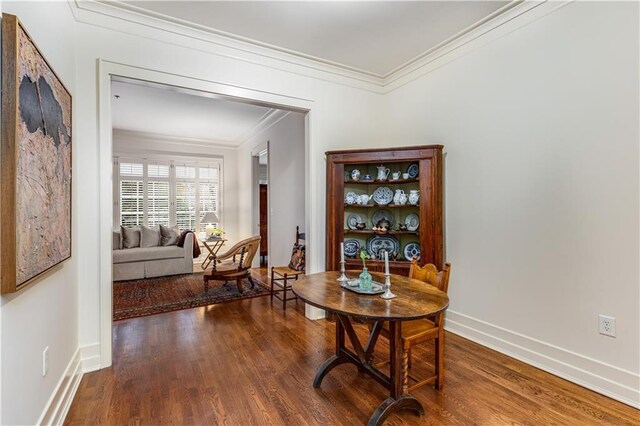 dining space featuring crown molding, baseboards, and wood finished floors