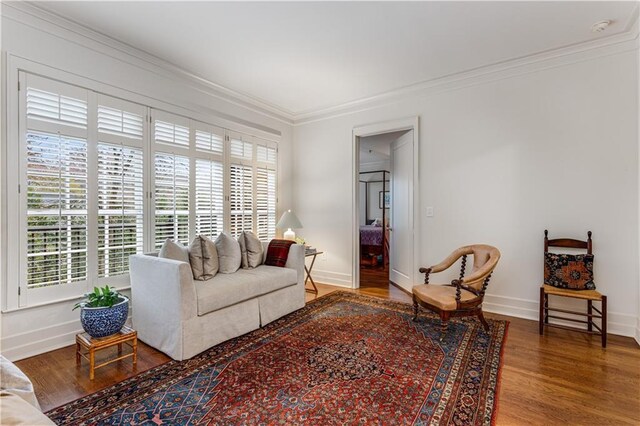 living area with ornamental molding, baseboards, and wood finished floors