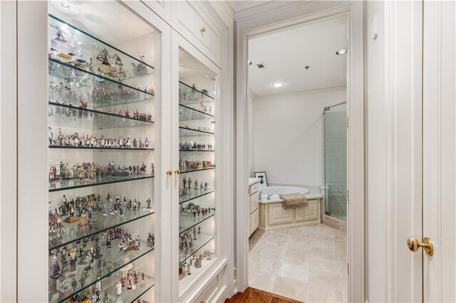 bathroom with a garden tub, a shower stall, and crown molding