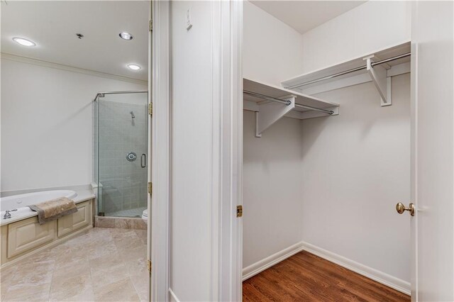 bathroom with recessed lighting, baseboards, a bath, a stall shower, and crown molding