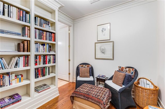 sitting room featuring crown molding and wood finished floors