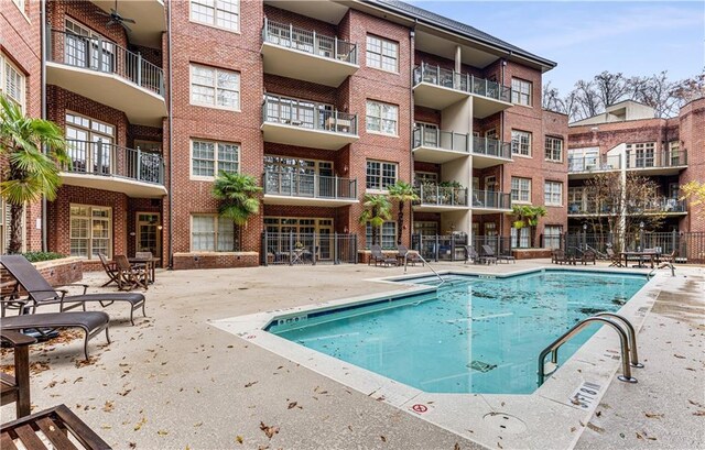 view of swimming pool with a patio area and fence