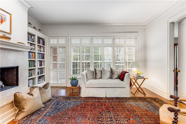 interior space with ornamental molding, a premium fireplace, wood finished floors, and built in features