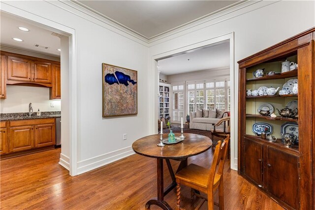 dining area featuring recessed lighting, baseboards, crown molding, and wood finished floors