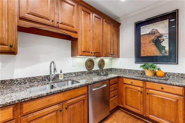 kitchen with dark stone counters, brown cabinets, dishwasher, and a sink