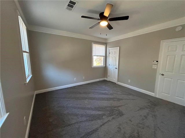 spare room with ceiling fan, dark carpet, and ornamental molding