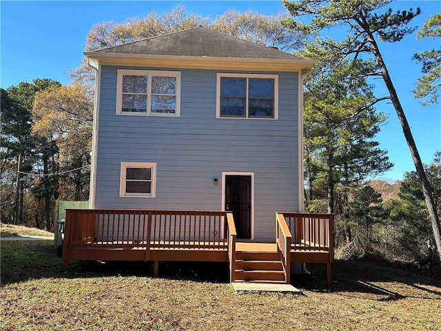 back of property with a lawn and a wooden deck