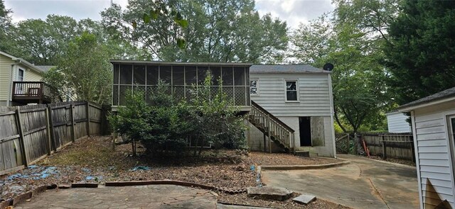 back of property with a patio and a sunroom