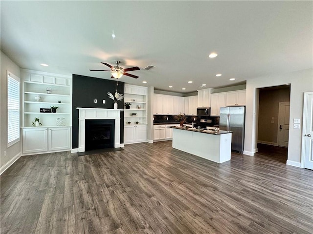 kitchen featuring stainless steel appliances, ceiling fan, dark wood-type flooring, a center island, and white cabinetry