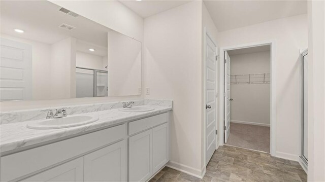 bathroom with vanity and a shower with door