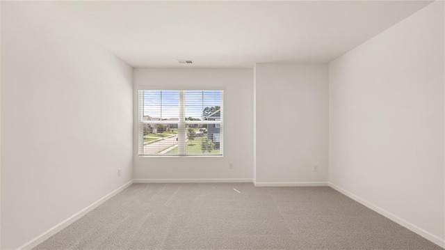 spare room featuring light colored carpet