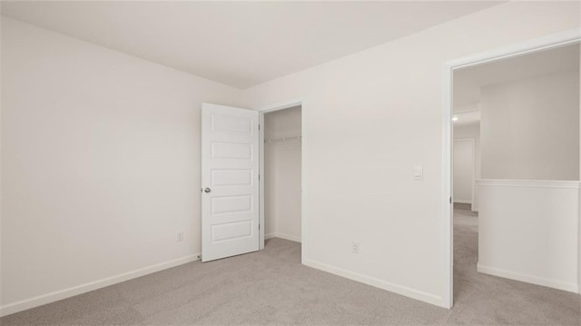 unfurnished bedroom with a closet and light carpet