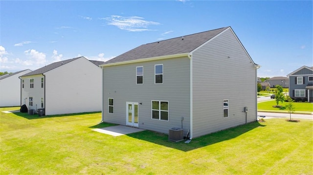 back of house featuring central air condition unit and a lawn