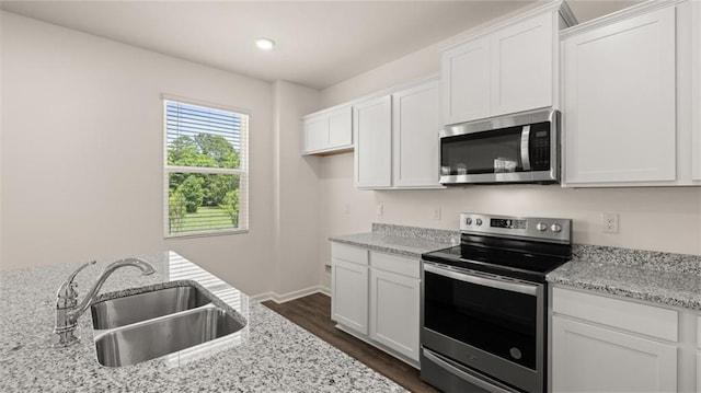 kitchen featuring sink, light stone countertops, white cabinets, and appliances with stainless steel finishes