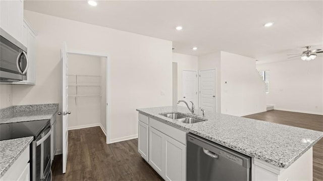 kitchen featuring appliances with stainless steel finishes, sink, a center island with sink, and white cabinets