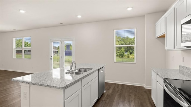 kitchen featuring white cabinetry, light stone countertops, a kitchen island with sink, and sink