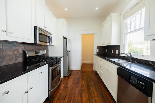 kitchen featuring a sink, baseboards, appliances with stainless steel finishes, white cabinets, and dark wood-style flooring