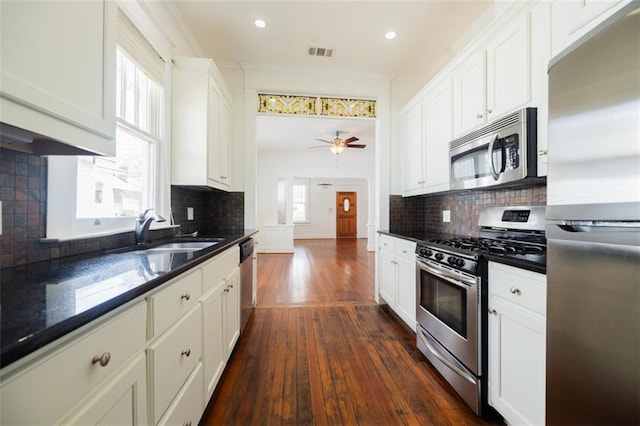 kitchen with stainless steel appliances, plenty of natural light, dark wood-type flooring, and visible vents