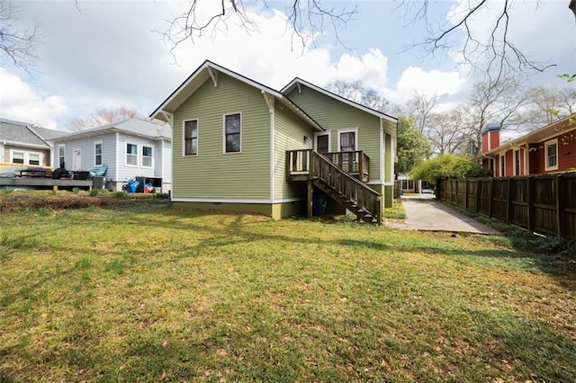 rear view of property featuring a lawn, fence, stairway, crawl space, and a patio area