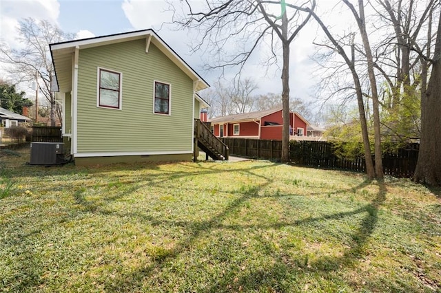 rear view of house with fence, a yard, stairway, cooling unit, and crawl space