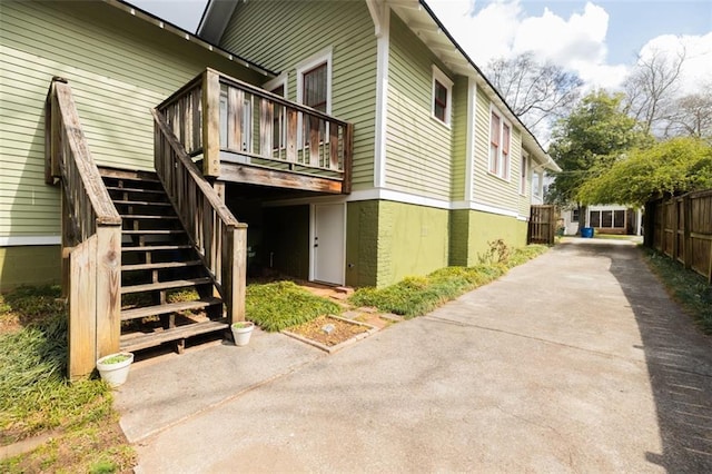 view of side of home with stairs and fence