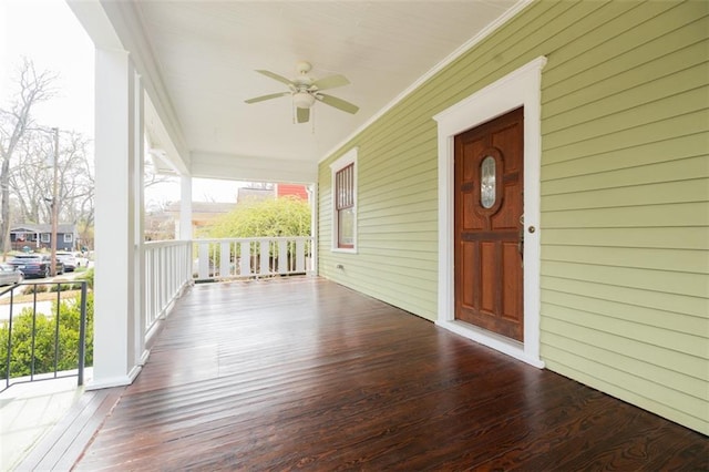 wooden deck featuring covered porch and a ceiling fan