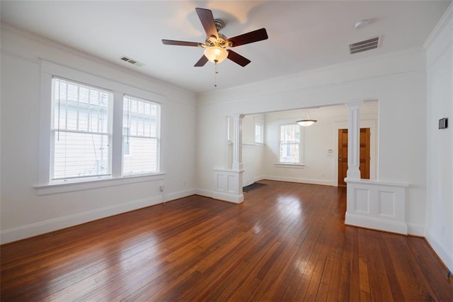 empty room featuring decorative columns, a ceiling fan, visible vents, and dark wood-style flooring