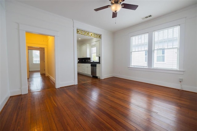 empty room featuring visible vents, baseboards, dark wood-type flooring, and ceiling fan