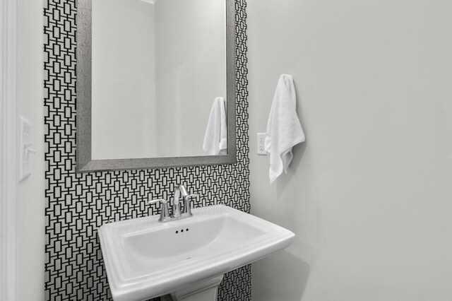 bathroom featuring sink and backsplash