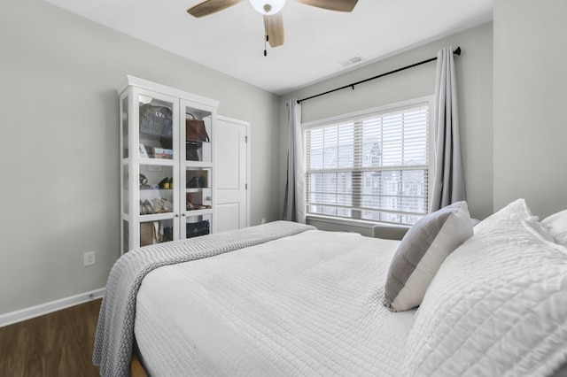 bedroom with dark hardwood / wood-style floors and ceiling fan