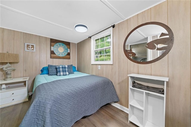 bedroom with wooden walls and wood finished floors