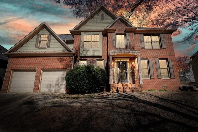 view of front of property with driveway and brick siding