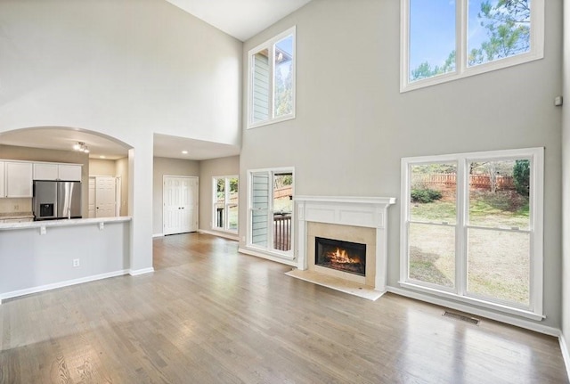 unfurnished living room featuring plenty of natural light, visible vents, and light wood finished floors