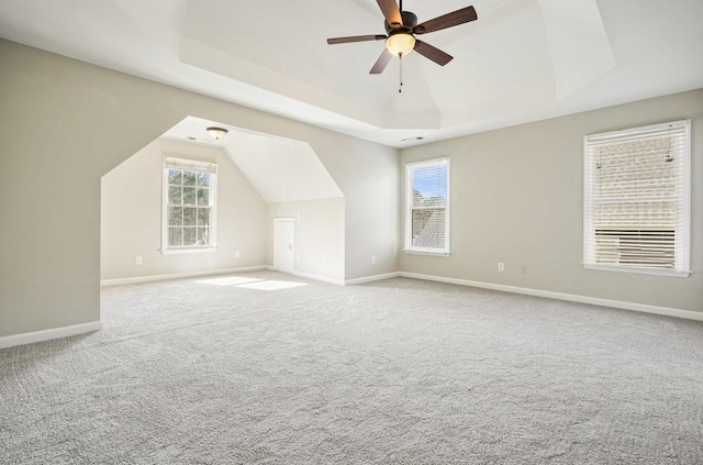 additional living space with baseboards, a ceiling fan, and light carpet