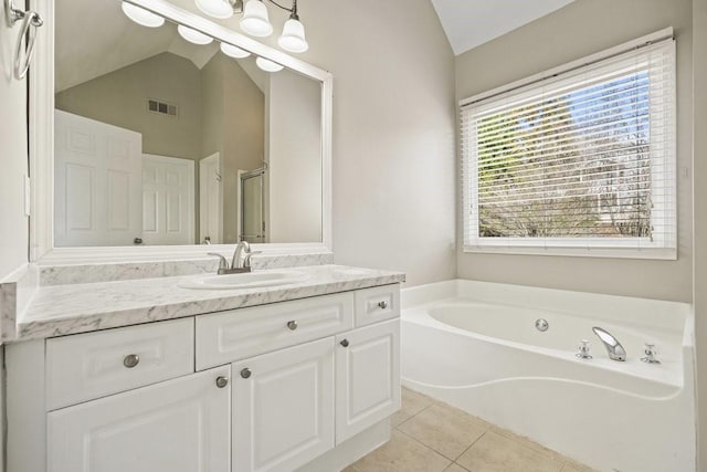 bathroom featuring visible vents, vaulted ceiling, a garden tub, and tile patterned flooring