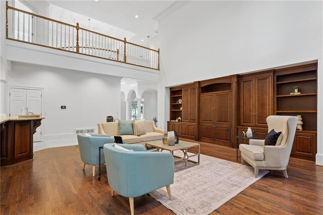 living room featuring a high ceiling and dark hardwood / wood-style floors