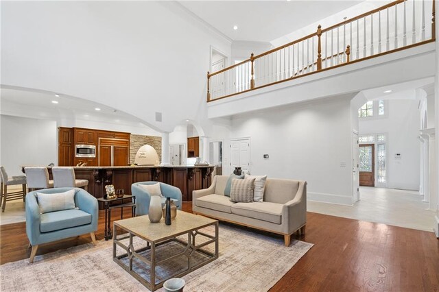 living room with a towering ceiling and light hardwood / wood-style floors