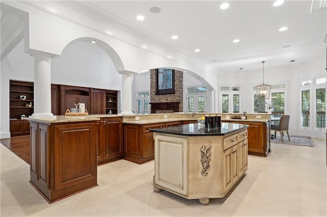 kitchen featuring light stone countertops, hanging light fixtures, and a large island