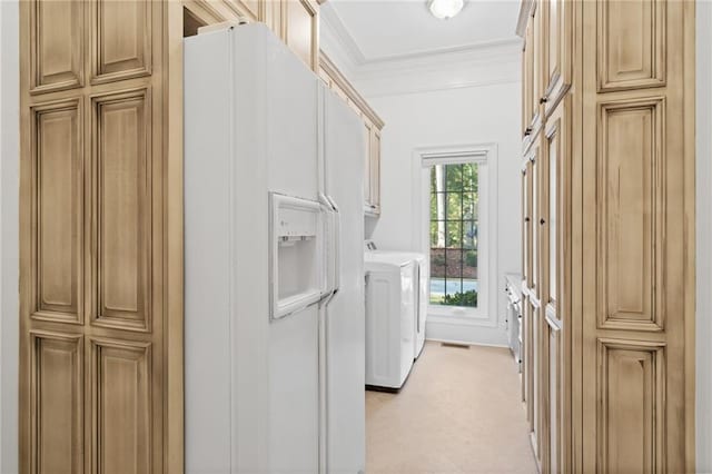 laundry room featuring washing machine and dryer, cabinets, and ornamental molding